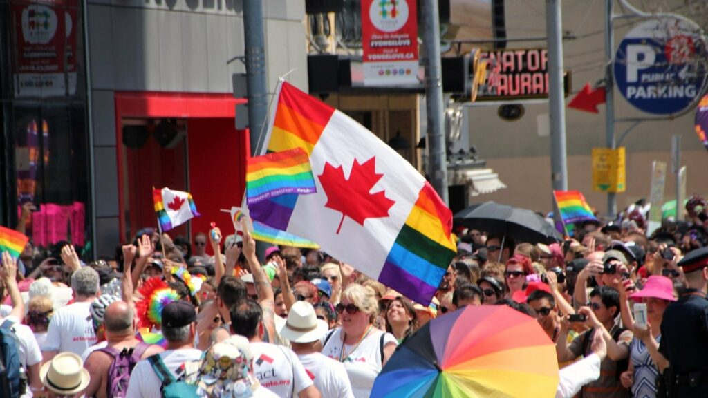 people in the streets and canadian lgbt flag