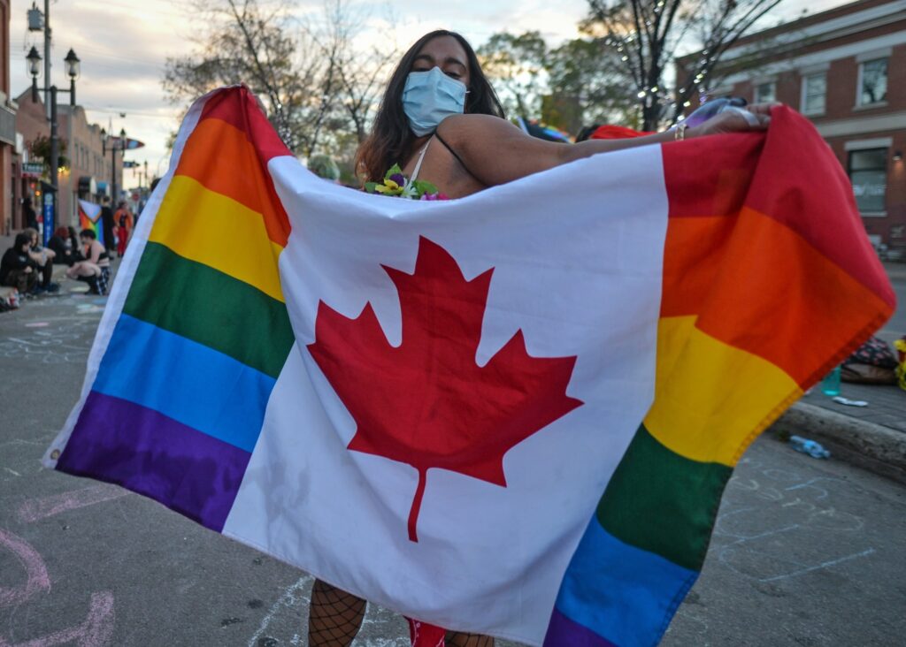 woman holding a canadian lgbt flag